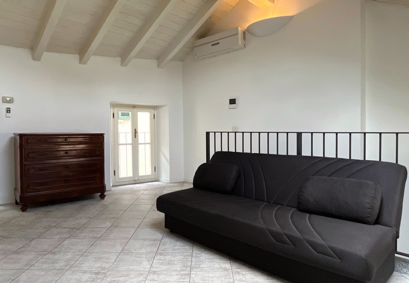 Soggiorno con travi a vista, un comodo divano e una cassettiera Confortevole e luminoso