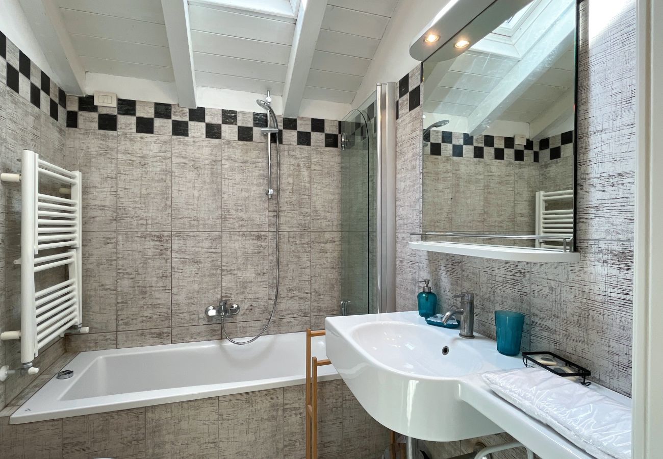 Bagno moderno con lucernario, sanitari essenziali e vasca da bagno Bagno moderno con lucernario e vasca