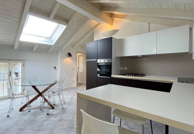 Modern kitchen with peninsula, skylight, and balcony access. Elegant kitchen with balcony access.