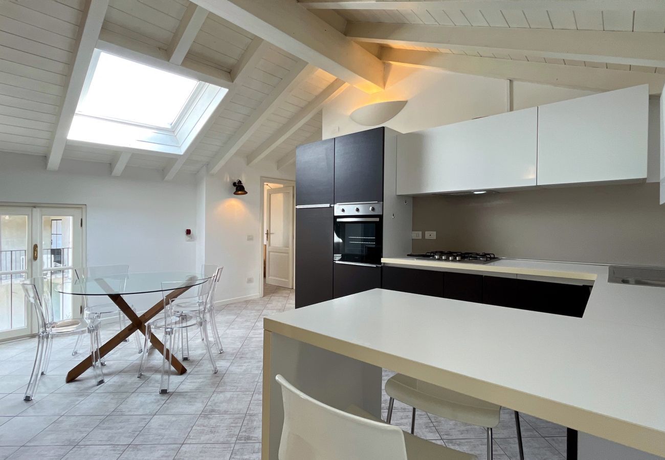 Modern kitchen with peninsula, skylight, and balcony access. Elegant kitchen with balcony access.